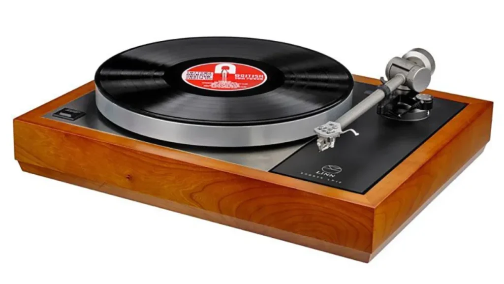 A vintage turntable with a wooden base and a vinyl record on the platter. The tonearm is positioned over the record. For soundhub's blog Best  Audio Accessories.